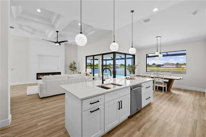 Kitchen featuring a fireplace, a wealth  natural light, white cabinets