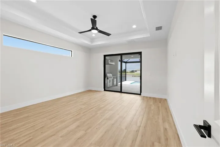 Master bedroom with a raised ceiling and ceiling fan