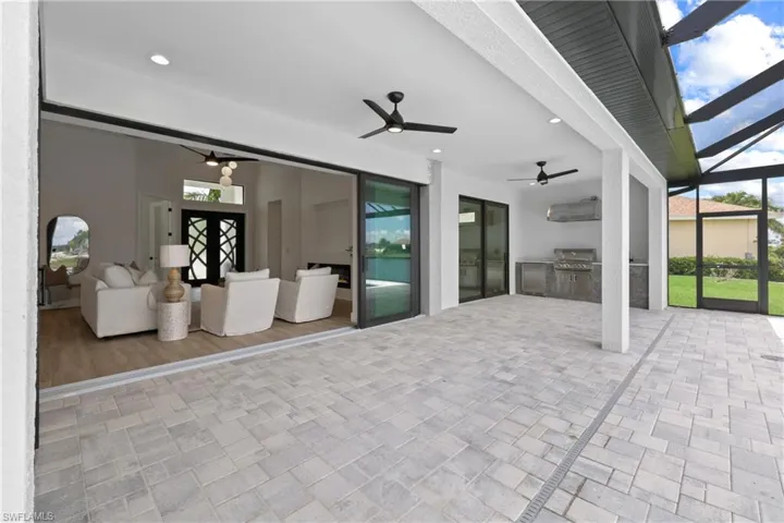 View of patio / terrace with summer kitchen, a lanai, an outdoor kitchen, and ceiling fan