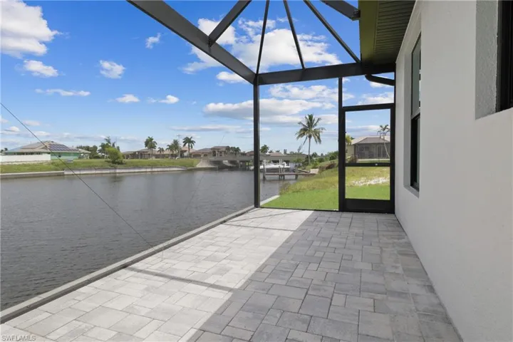 View of patio with a lanai and a water view