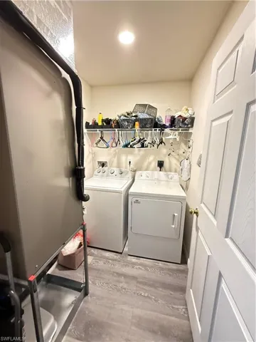 Laundry room featuring washer and dryer and light wood-type flooring