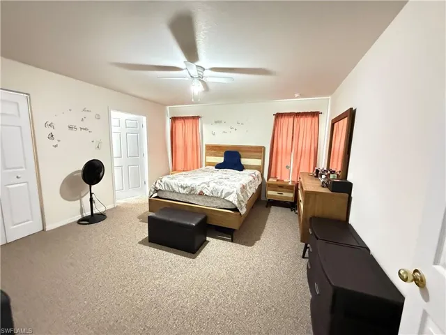 Bedroom featuring light colored carpet and a ceiling fan