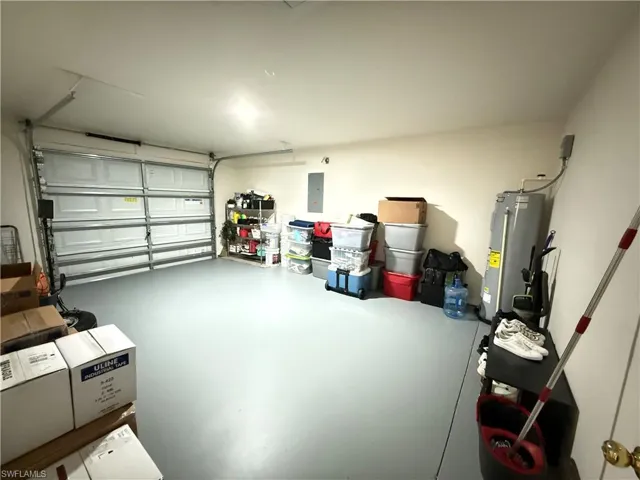 Garage featuring water heater and electric panel