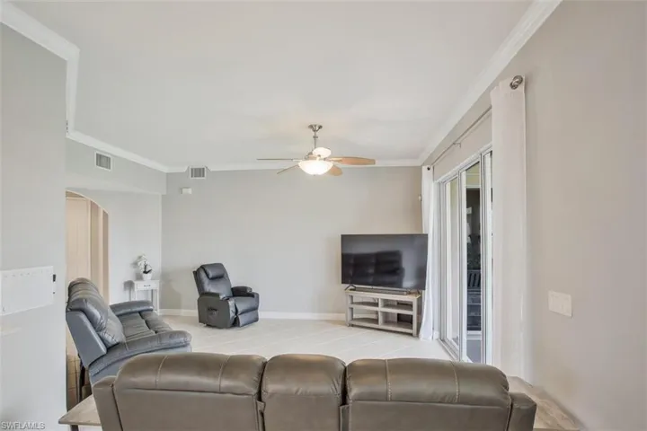 Living room with ceiling fan and crown molding