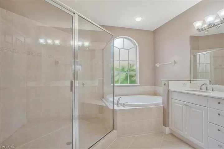 Bathroom featuring vanity, independent shower and bath, and tile patterned flooring