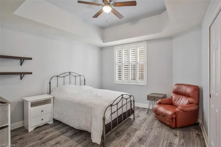 Bedroom featuring ceiling fan, hardwood / wood-style flooring, a closet, and a raised ceiling