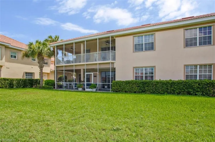 Back of property featuring a sunroom and a yard