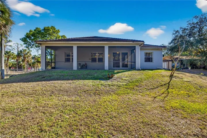 Back of property featuring stucco siding and a sunroom