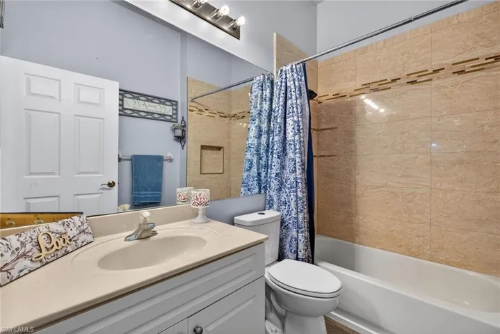 Bathroom featuring vanity and shower / bath combo with shower curtain