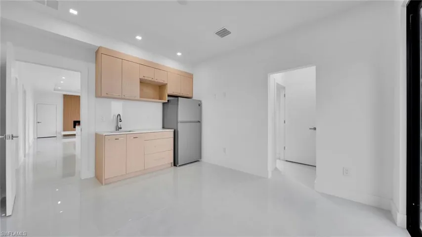 Kitchen with light brown cabinets, light countertops, freestanding refrigerator, recessed lighting, and modern cabinets