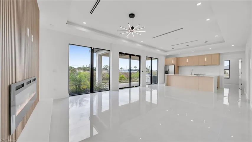 Unfurnished living room with a fireplace, recessed lighting, and a chandelier