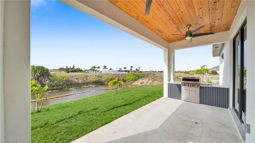 View of patio / terrace featuring ceiling fan, a water view, and grilling area