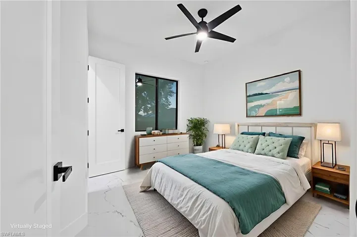 Bedroom with marble look tiles and ceiling fan