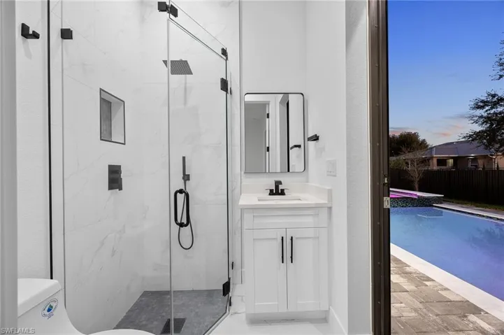 Full bath featuring a marble finish shower and vanity