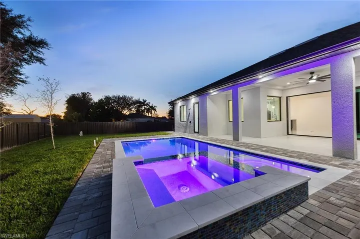 View of pool with a patio area, a fenced backyard, and a pool with connected hot tub