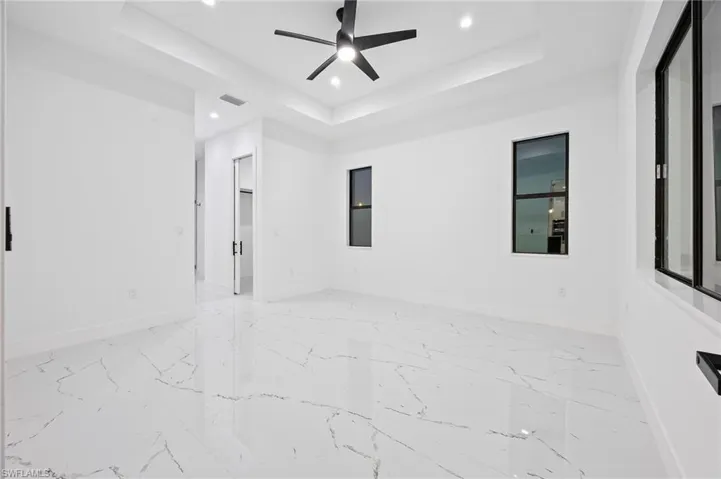 Spare room featuring a tray ceiling, recessed lighting, and ceiling fan
