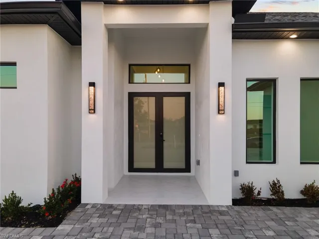 Entrance to property featuring stucco siding and french doors