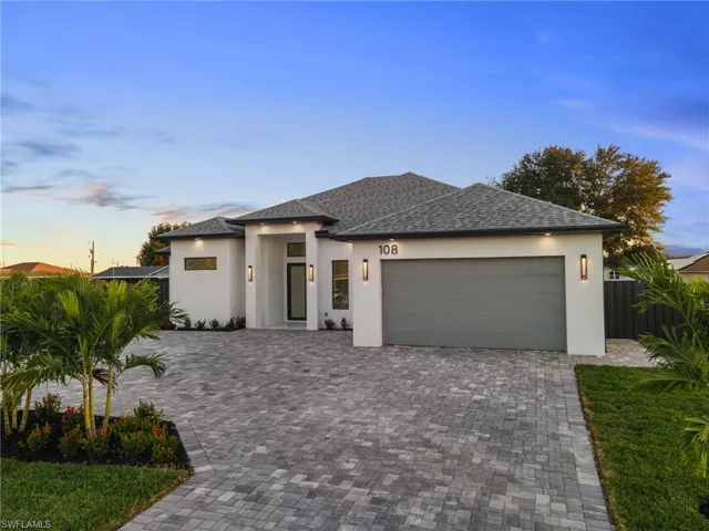 Prairie-style home with a garage, decorative driveway, stucco siding, and a shingled roof