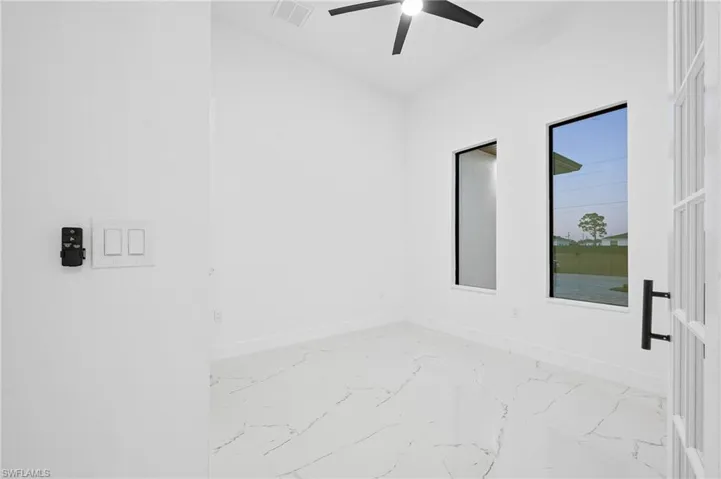 Unfurnished room with baseboards and light marble finish flooring