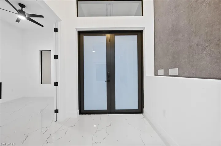 Entrance to property with a ceiling fan, stucco siding, and french doors