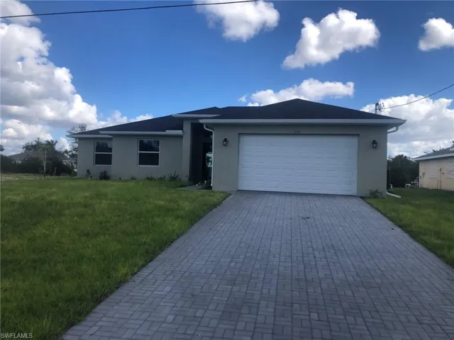 View of front of property with a front lawn and a garage