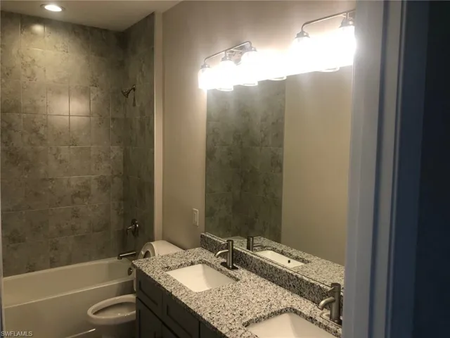 Full guest bathroom with vanity, tiled shower / bath, and toilet