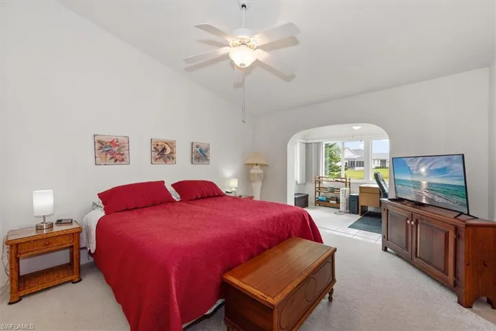 Bright interior featuring vaulted ceilings and a ceiling fan with integrated lighting