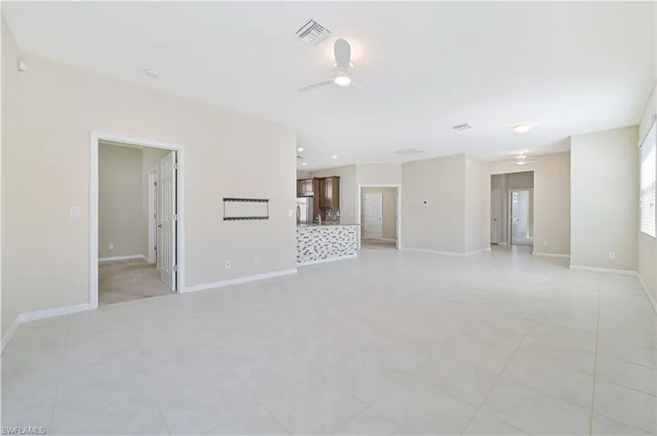 Unfurnished living room with a ceiling fan and light tile patterned floors