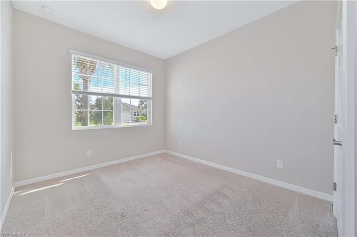 Spare room with light colored carpet and baseboards