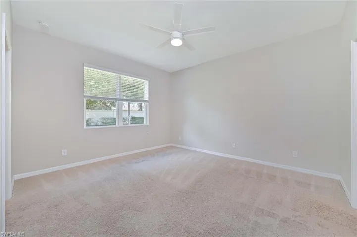 Spare room with light carpet and a ceiling fan