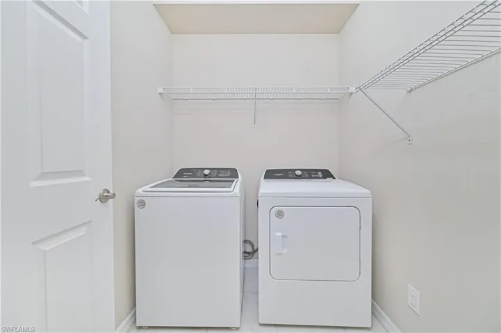 Laundry area with baseboards and washer and clothes dryer