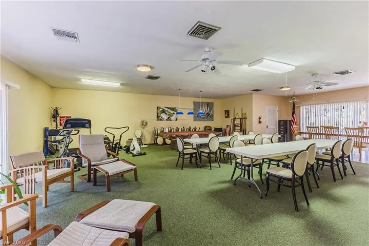 Carpeted dining room with ceiling fan