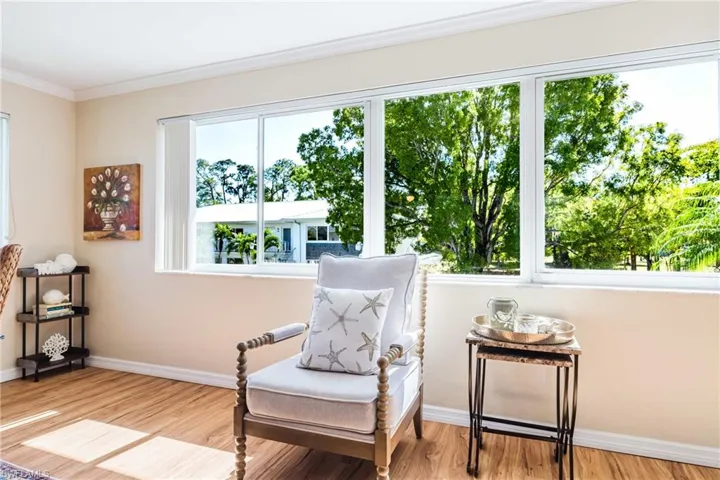 Sitting room with light wood finished floors and crown molding