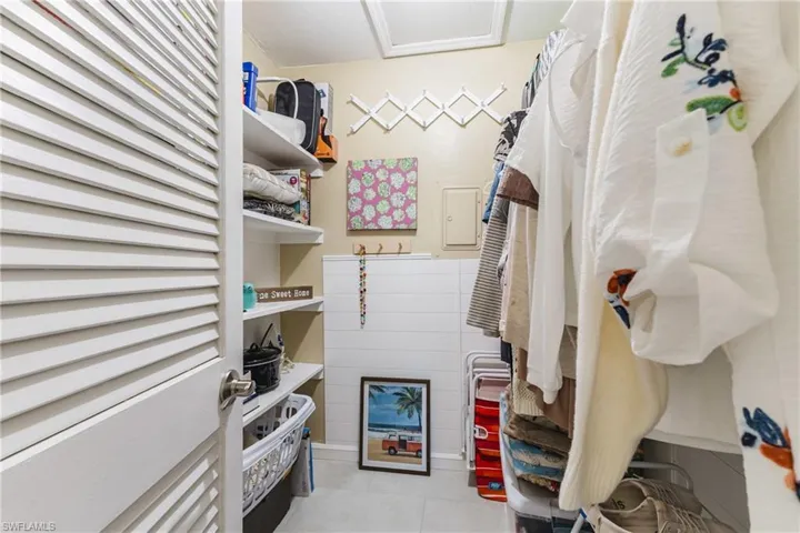 Walk in closet featuring electric panel and light tile patterned flooring