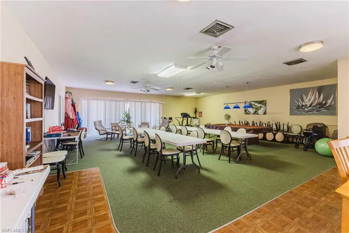 Dining space with dark colored carpet and a ceiling fan