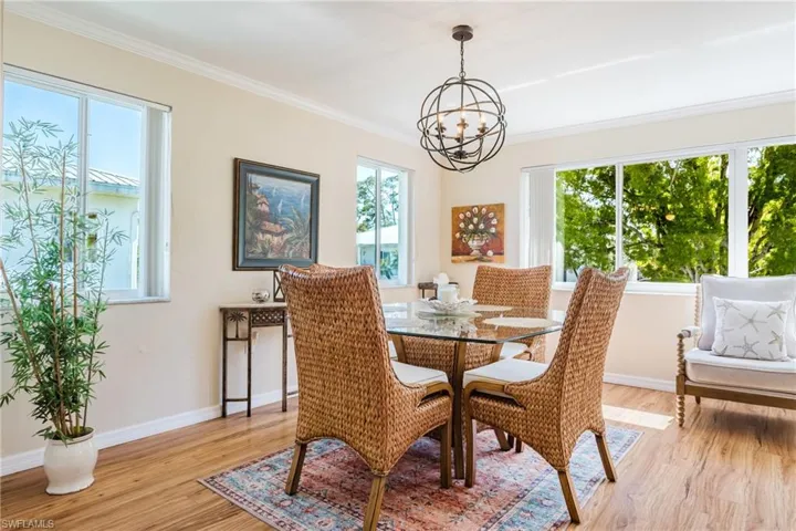 Dining room with a chandelier, light wood-style flooring, and crown molding