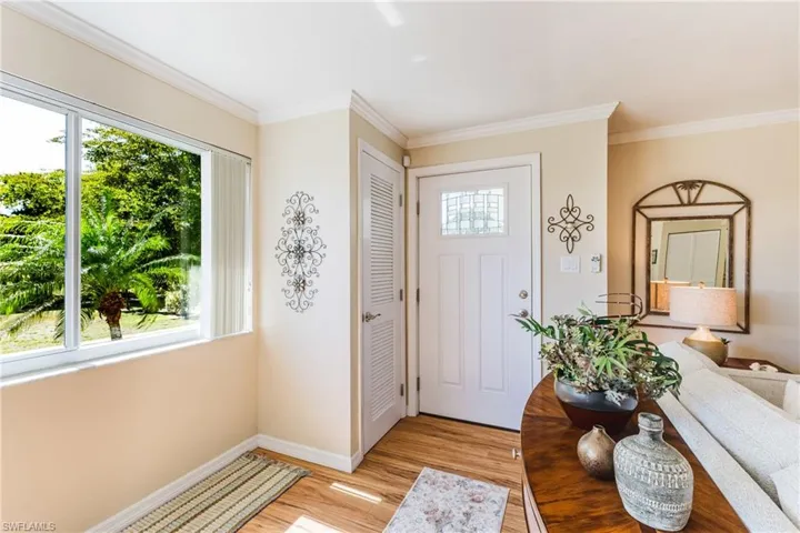 Foyer featuring crown molding and light wood-style floors