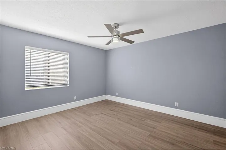 Spare room featuring light wood-style floors, ceiling fan, and a textured ceiling