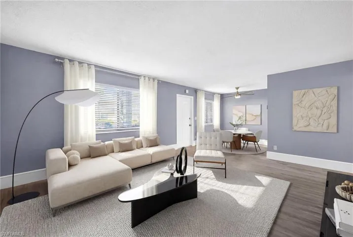 Living room featuring wood finished floors, ceiling fan, and a textured ceiling