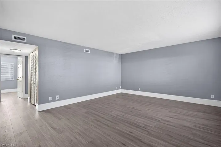 Unfurnished room with dark wood-style flooring and a textured ceiling