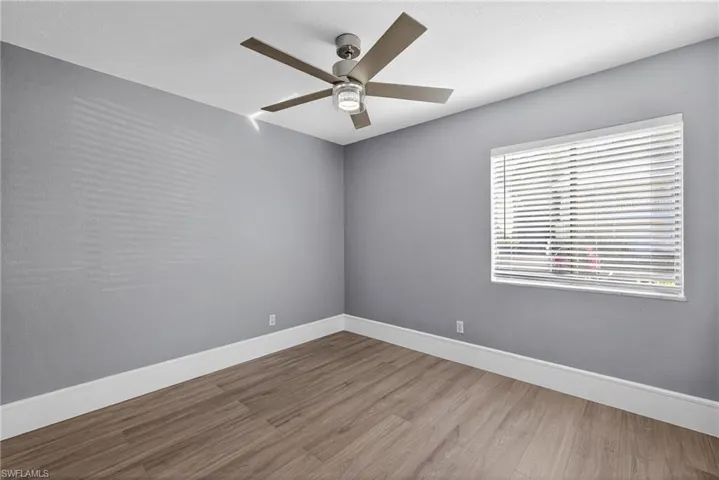 Unfurnished room featuring a ceiling fan and wood finished floors