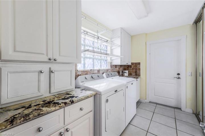 Laundry room with granite countertops, storage and new washer/dryer.