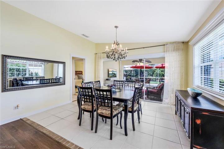 Dining room with chandelier and access to pocket sliding doors out to the lanai and primary suite.