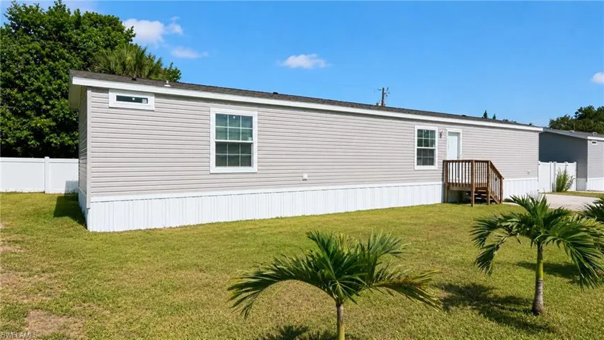 Light gray siding exterior with white trim and white vinyl skirting