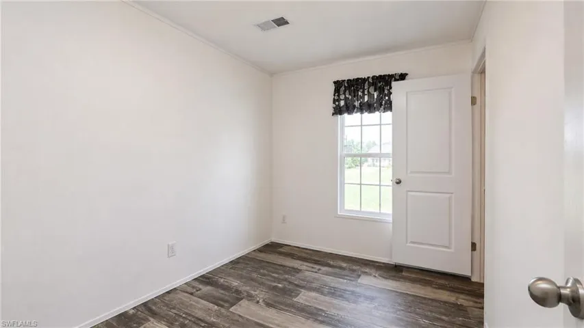 Interior room featuring wood-finish flooring and a white paneled door