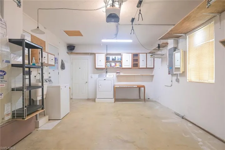 Basement featuring separate washer and dryer, electric panel, and sink