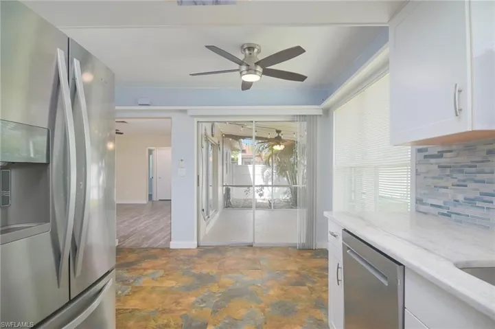 Kitchen with white cabinets, appliances with stainless steel finishes, a wealth of natural light, and ceiling fan