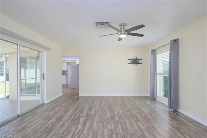 Spare room with dark wood-type flooring and ceiling fan