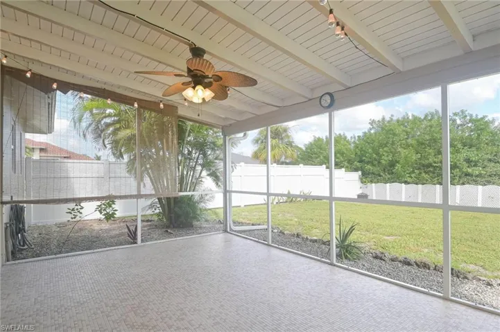 Unfurnished sunroom with lofted ceiling with beams, plenty of natural light, ceiling fan, and wood ceiling