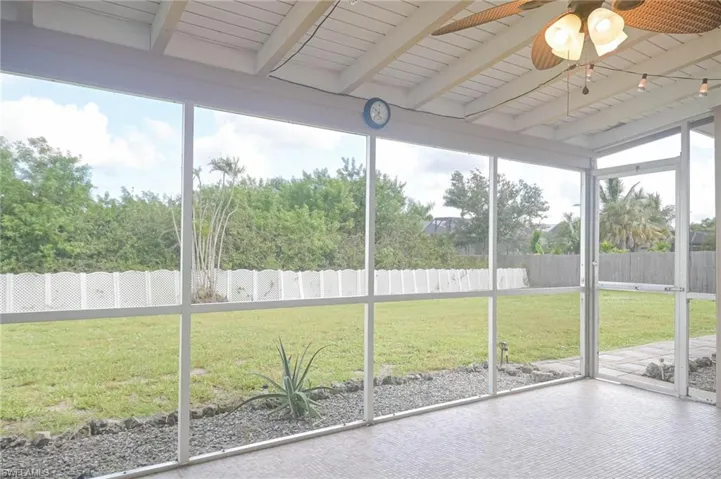 Unfurnished sunroom with ceiling fan, wood ceiling, lofted ceiling with beams, and a healthy amount of sunlight